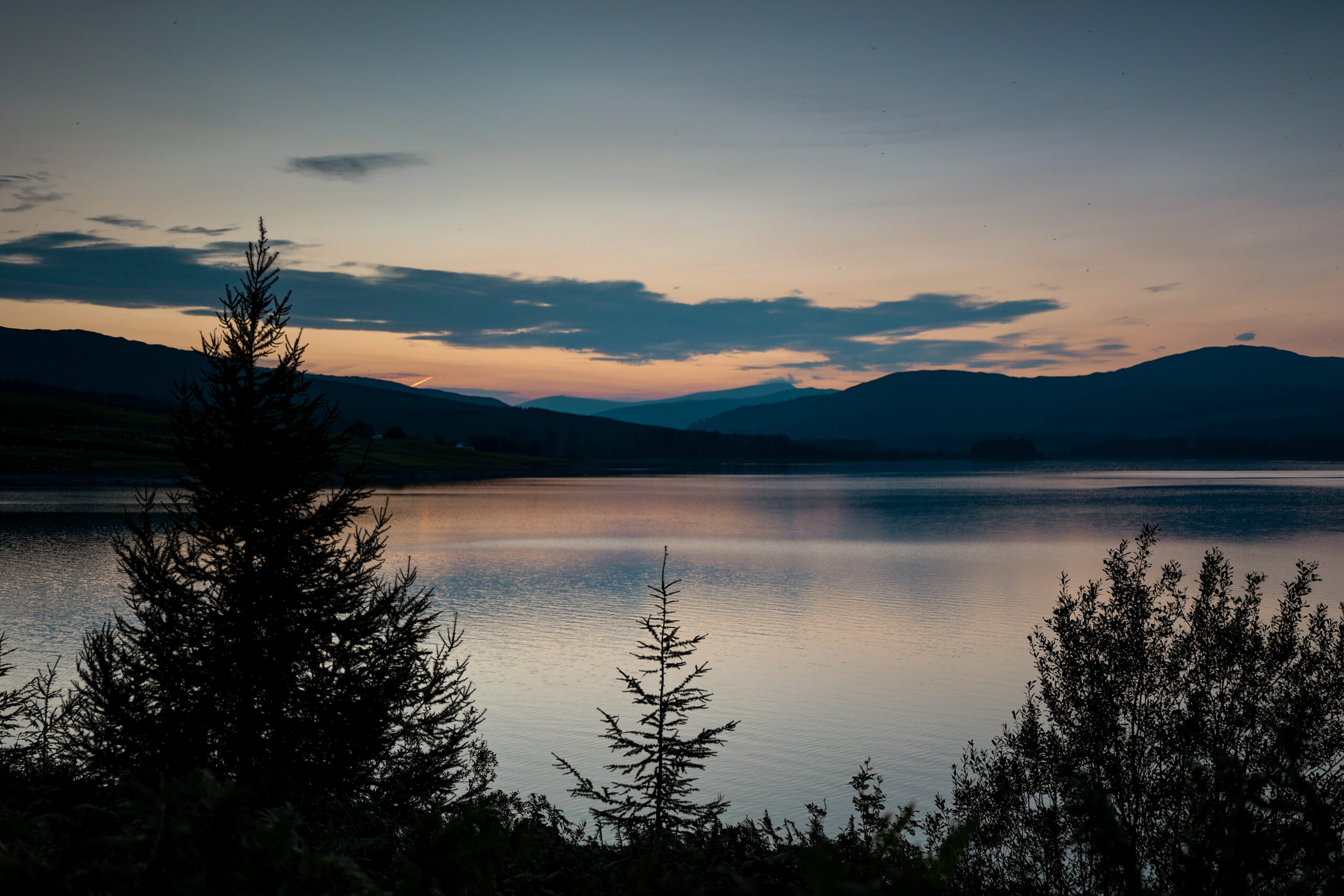 Sunet over Clatteringshaws Loch in Galloway Forest Park