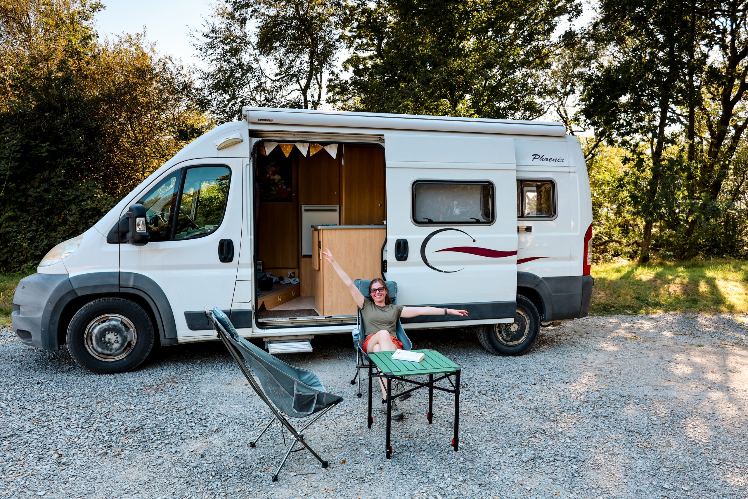 women with campervan sitting outside in Scotland