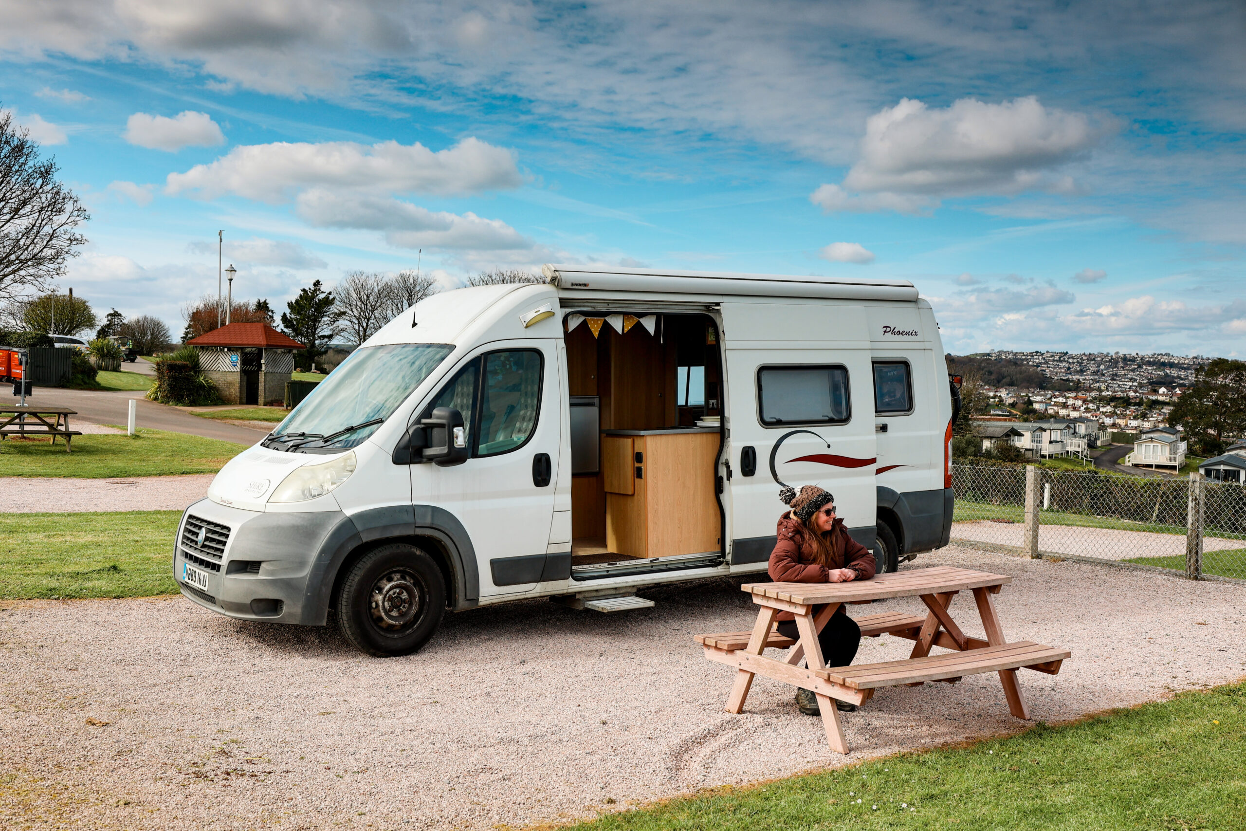 campervan and women sat a picnic bench